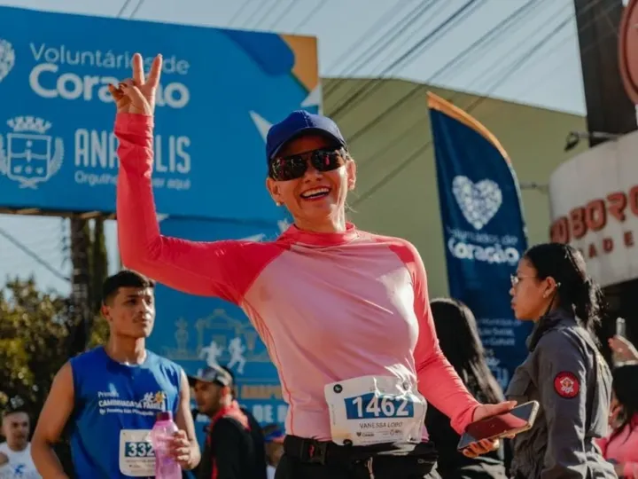 Uma mulher de boné e óculos escuro sorrindo