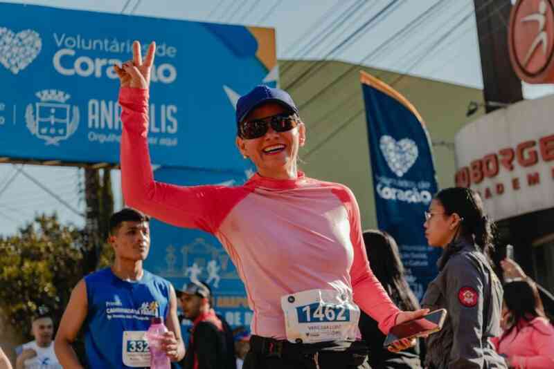 Uma mulher de boné e óculos escuro sorrindo