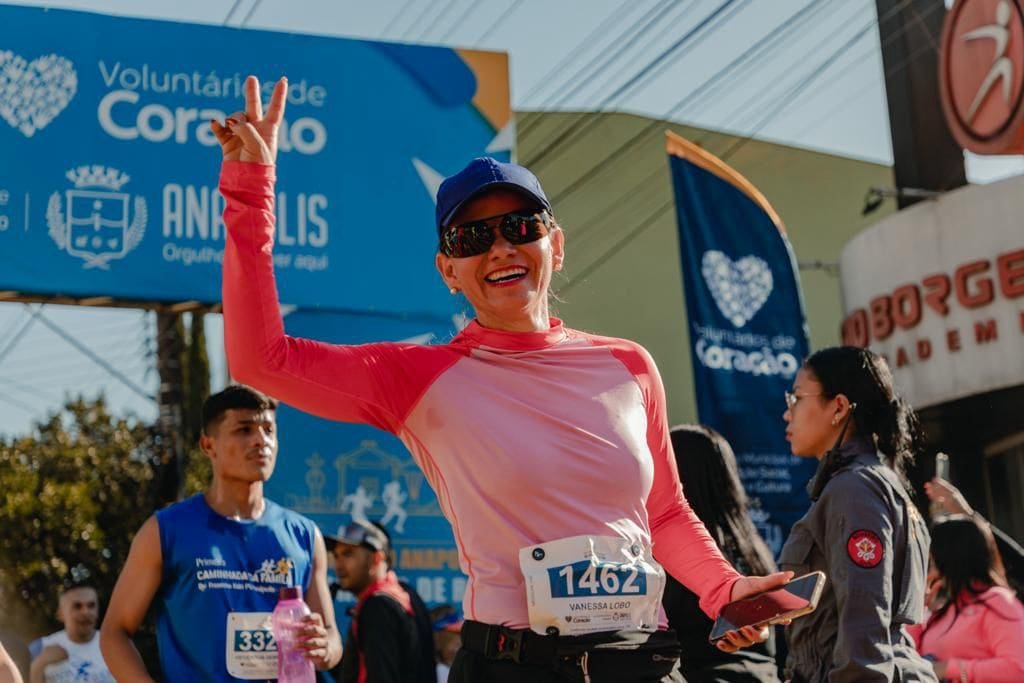 Uma mulher de boné e óculos escuro sorrindo