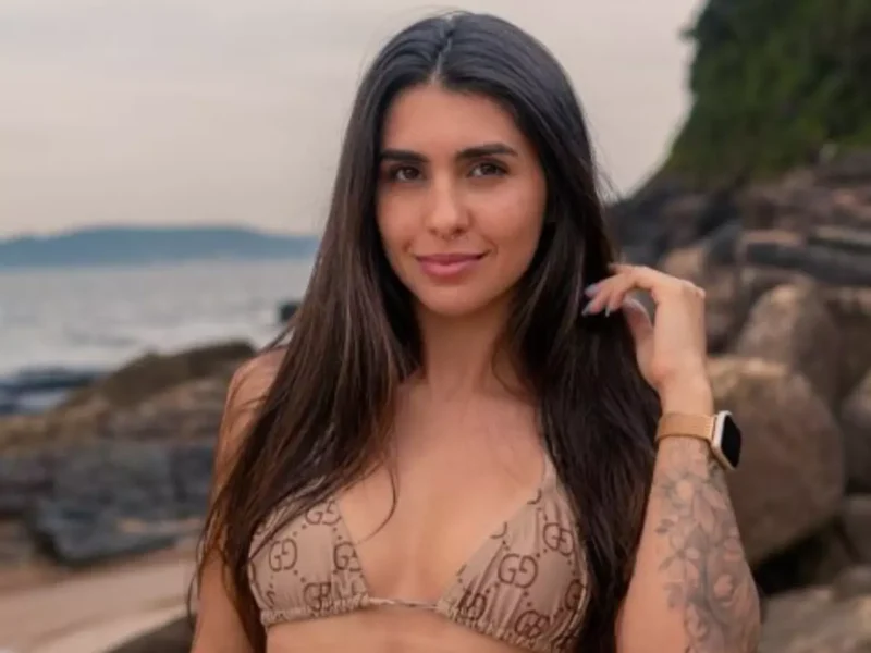 Sabrina Saraiva em biquíni bege à beira da praia, sorrindo para a câmera