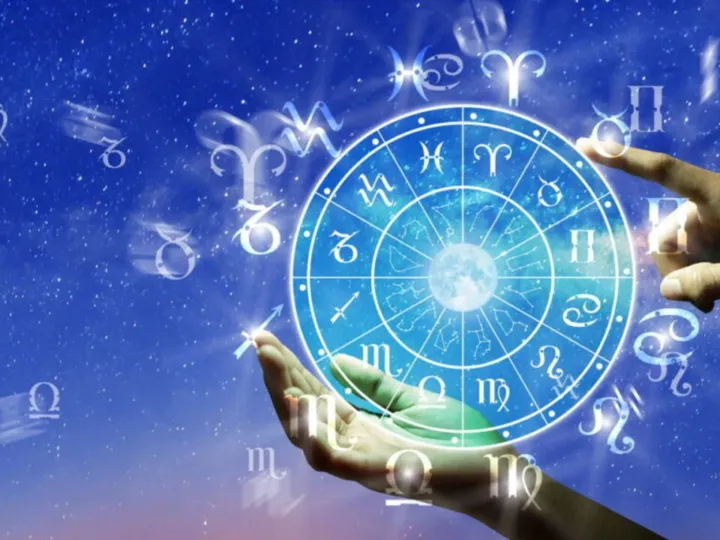 Mãos humanas apontando para um círculo com os doze signos do zodíaco, em um fundo de céu estrelado.