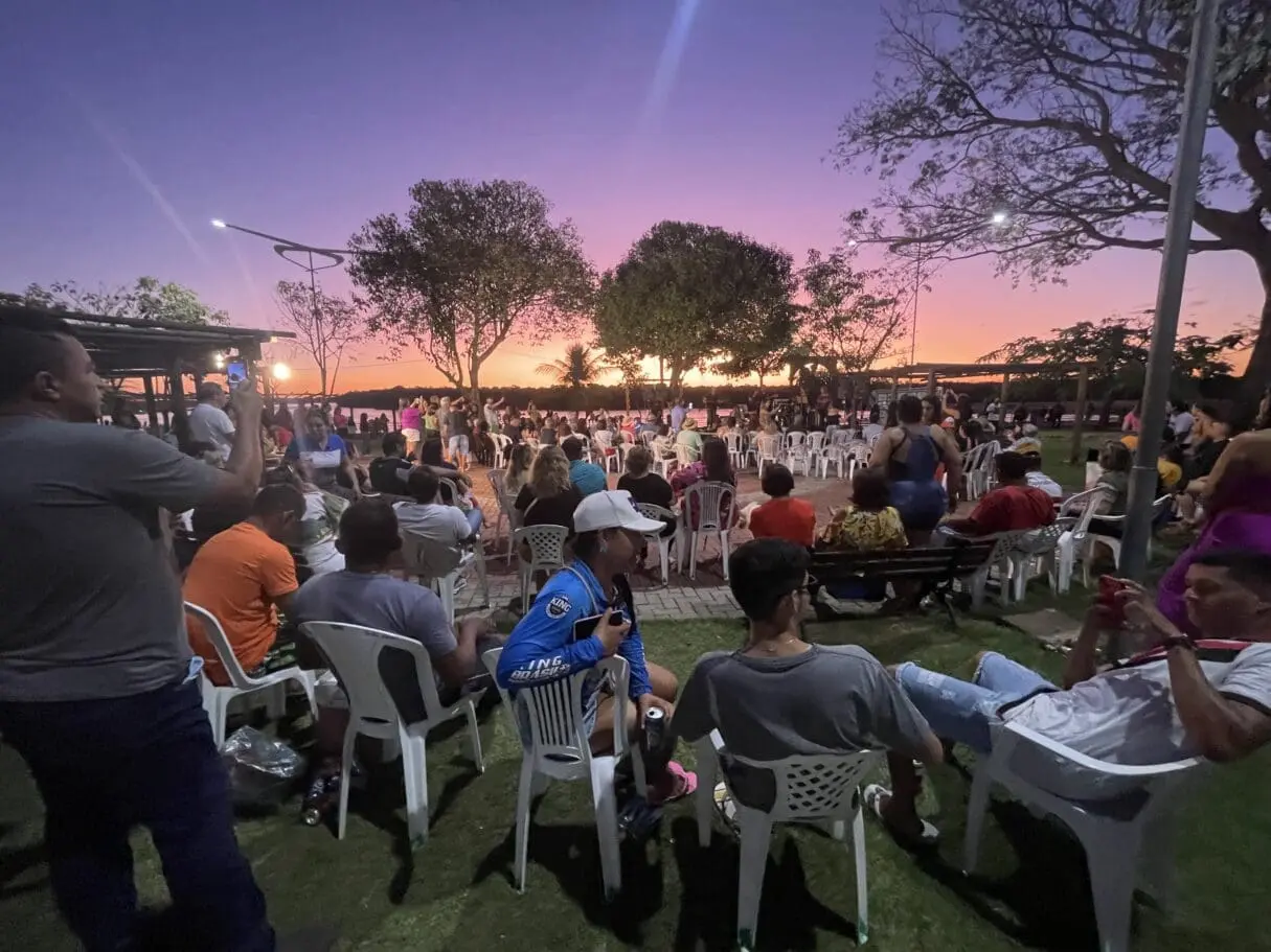 Turistas se reúnem ao pôr do sol às margens do Rio Araguaia durante a temporada de julho.