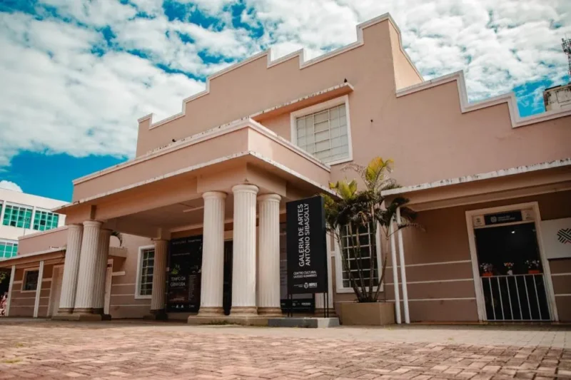 Fachada da Galeria de Artes Antônio Sibasolly, no Centro Cultural de Anápolis, sob céu azul com nuvens.