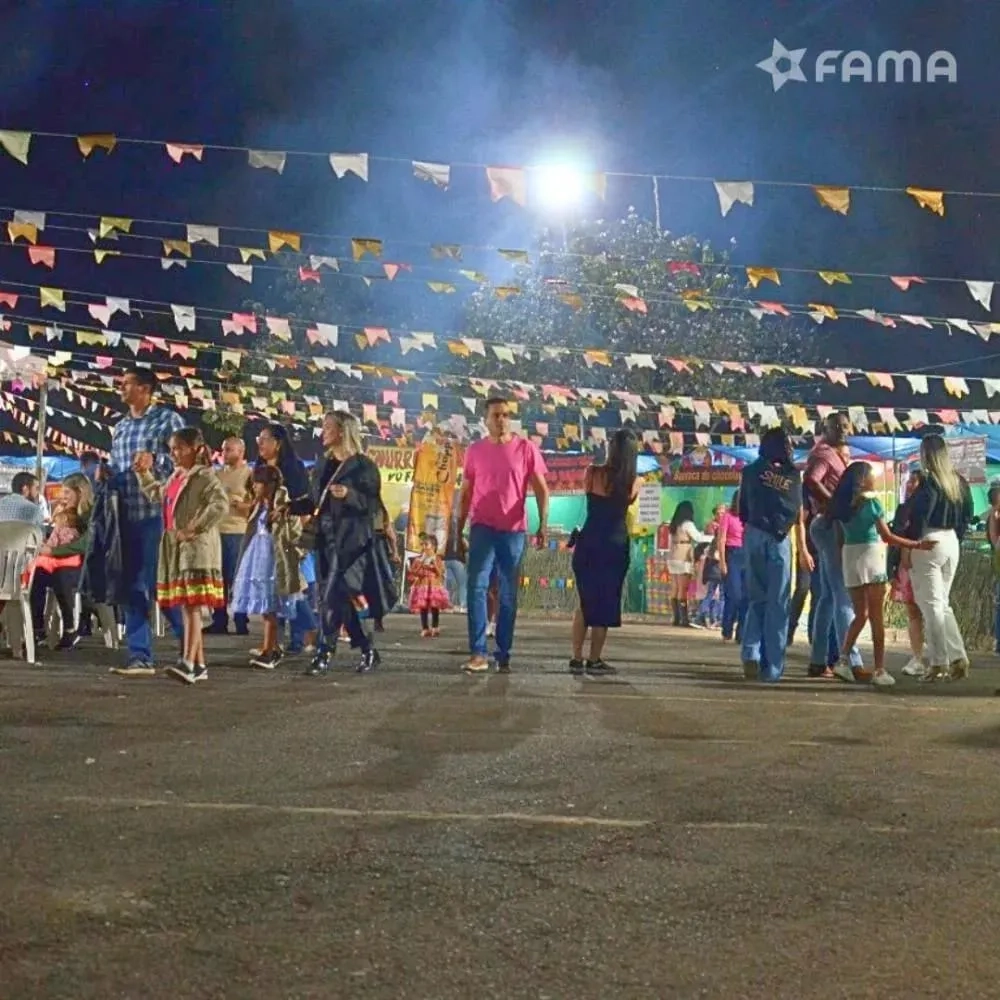 Pessoas participam da festa junina Arraiá BAAN 2024 com decoração típica e barracas temáticas