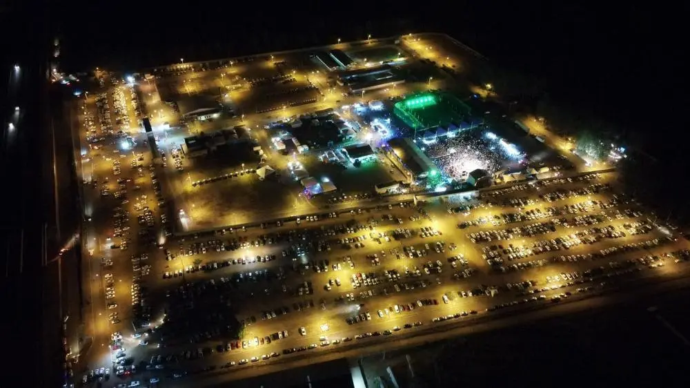 Imagem aérea da Expoana 2024 em Anápolis à noite, com grande público e estacionamento lotado