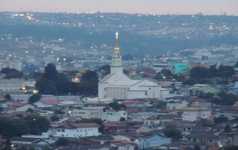Vista panorâmica de Anápolis com igreja iluminada ao entardecer.