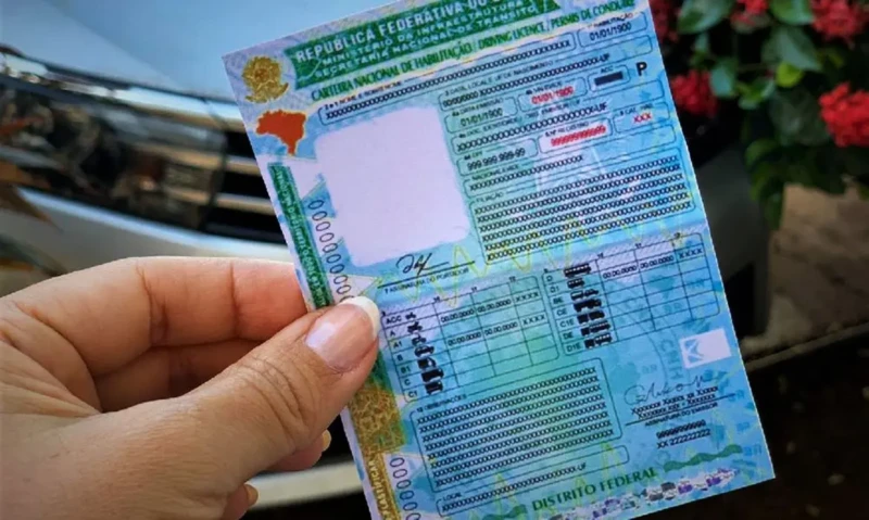 Modelo antigo da CNH sendo segurado por uma pessoa, representando o acesso gratuito à habilitação aprovado em 2025.