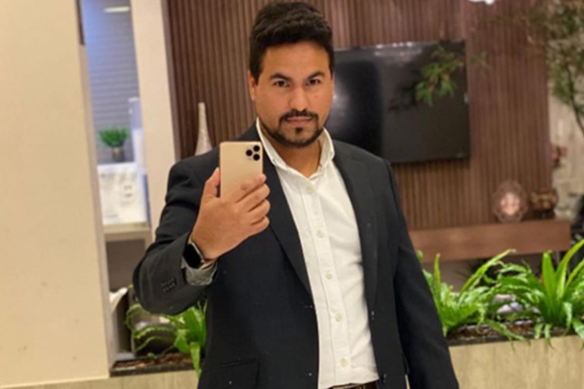 vereador acusado vestido de terno tirando foto no espelho