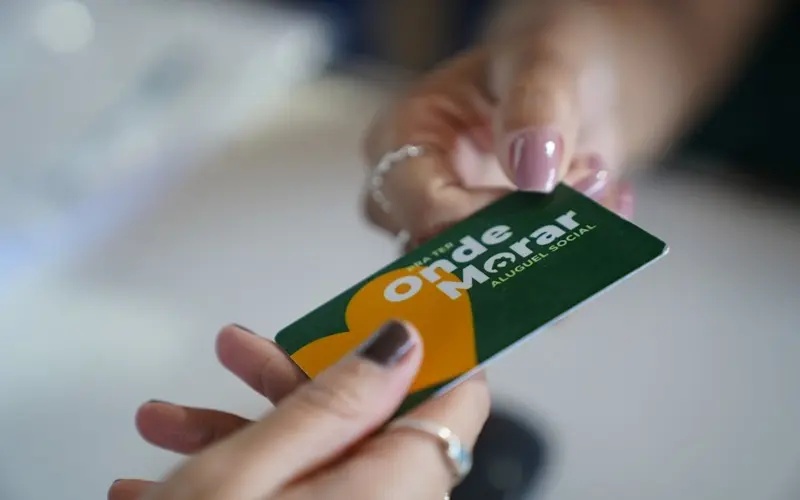 Cartão do programa Pra Ter Onde Morar sendo entregue durante ação do Governo de Goiás