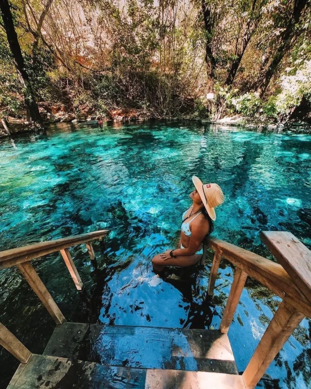 Mulher com chapéu de palha aproveita as águas azuis do Poço Azul em Aurora do Tocantins