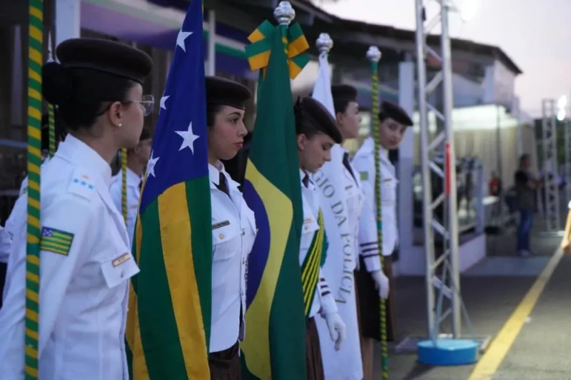Alunos uniformizados do Colégio Militar de Goiás em Anápolis segurando bandeiras em cerimônia cívica