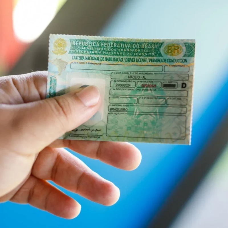 Pessoa segurando a nova Carteira Nacional de Habilitação emitida em Maceió, Alagoas