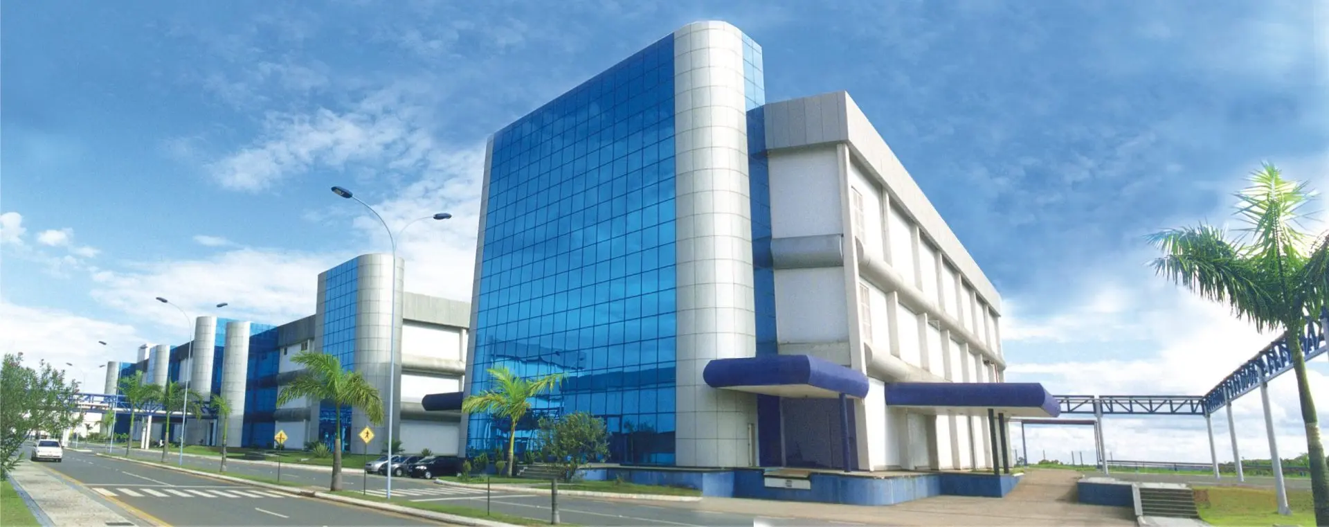 Prédio moderno da sede do Laboratório Teuto em Anápolis, com fachada espelhada e céu azul.