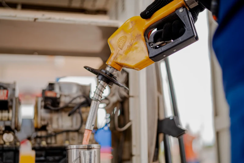 Bico de bomba de combustível sendo usado durante operação de abastecimento em posto