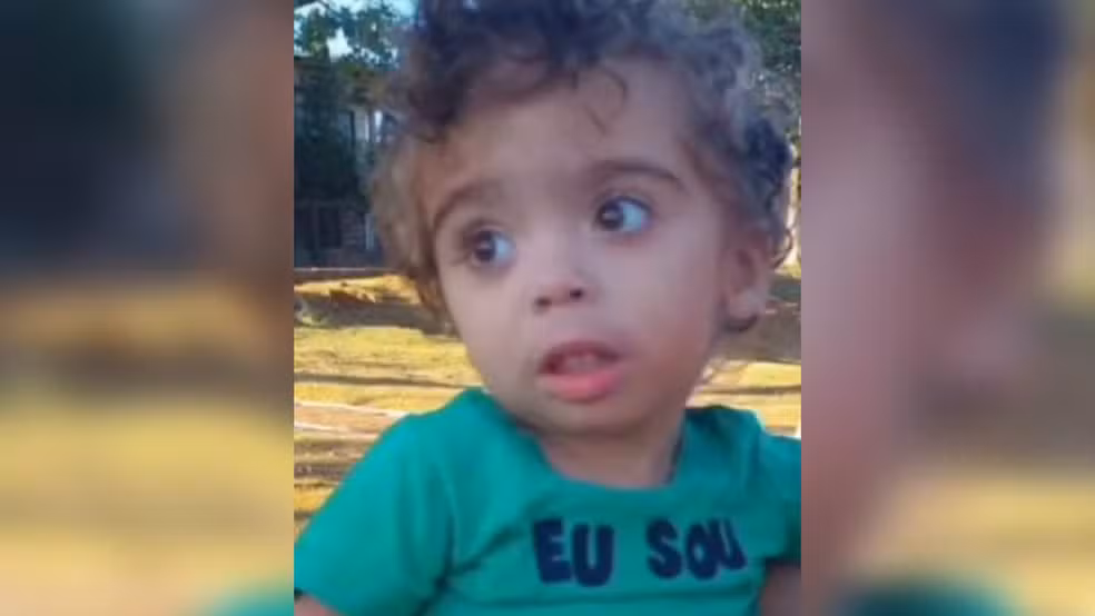 Criançade azul olhando para o lado com uma blusa azul