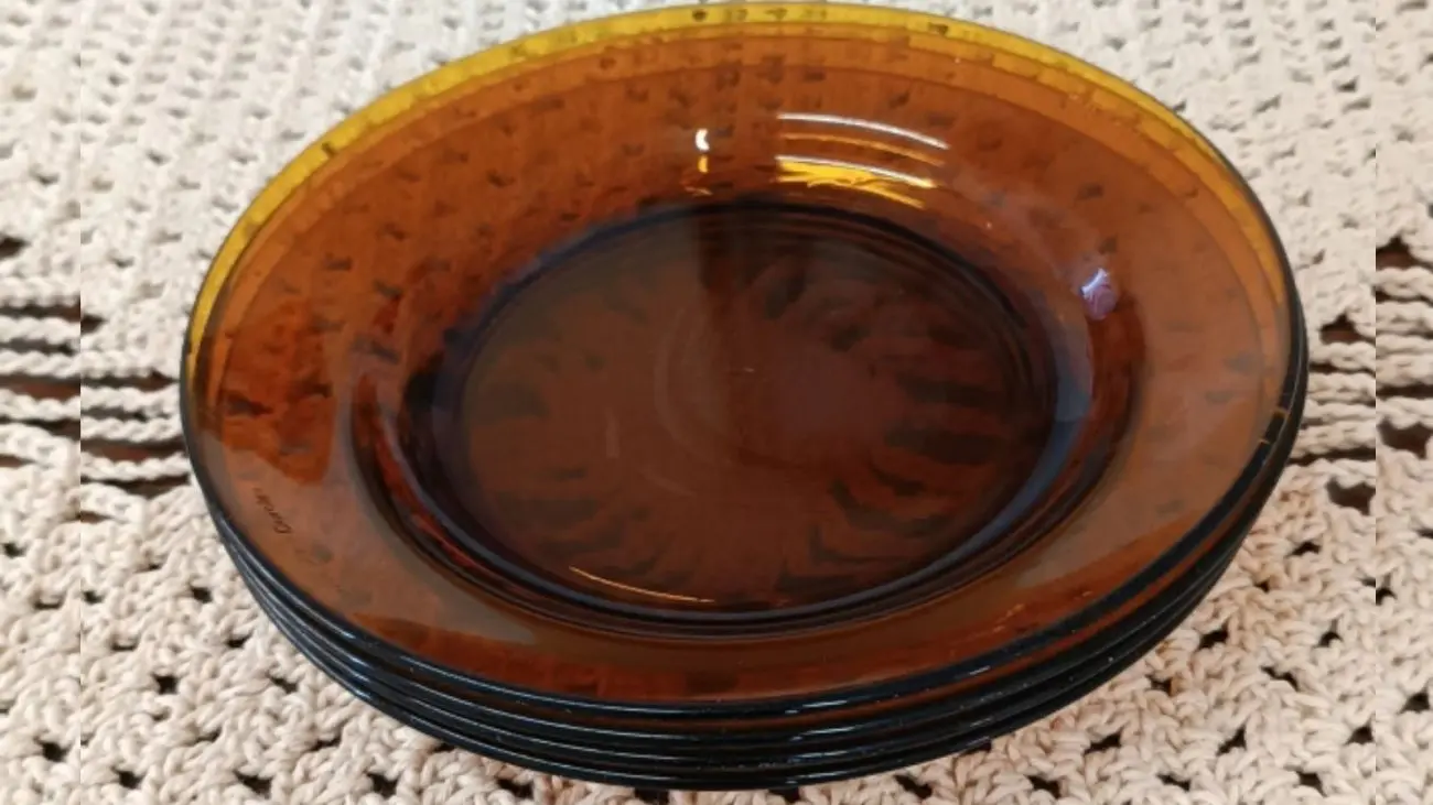 Pratos de vidro âmbar Duralex sobre toalha de crochê bege