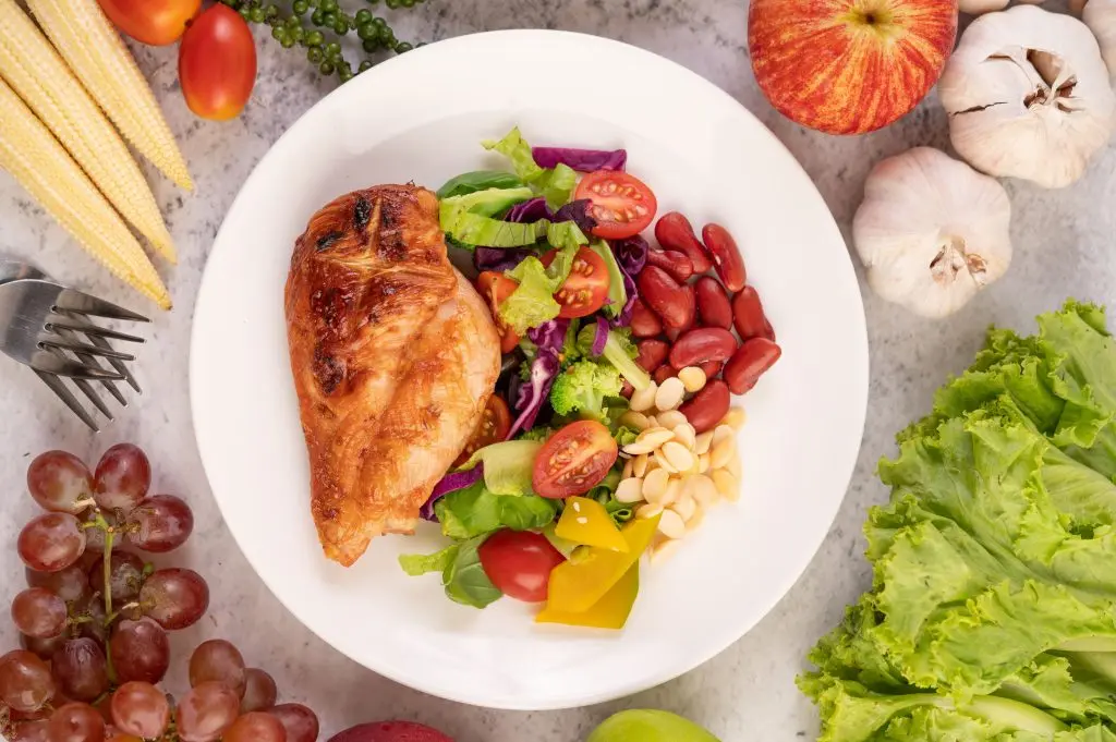 bife-de-frango-coberto-com-gergelim-branco-ervilhas-tomates-brocolis-e-abobora-em-um-prato-branco-1-1024x681