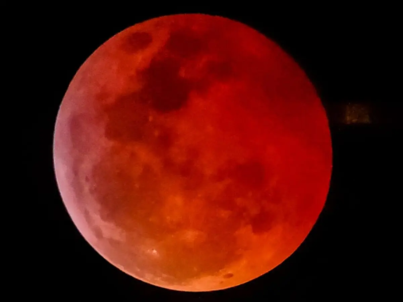 Eclipse lunar com a Lua em intensa coloração avermelhada, fenômeno conhecido popularmente como “Lua de Sangue”.