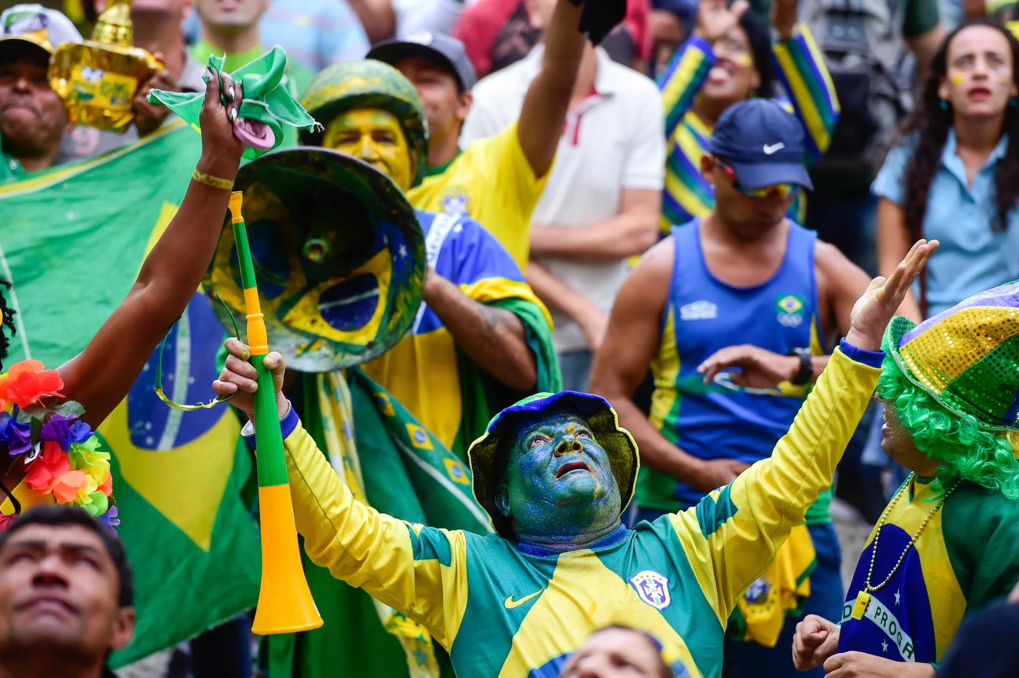 Torcedores brasileiros vestidos de verde e amarelo durante evento esportivo