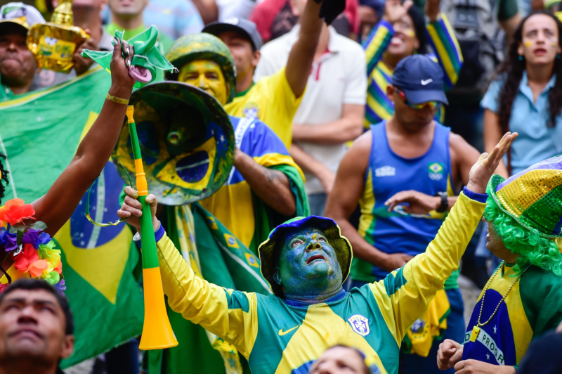 Torcedores brasileiros vestidos de verde e amarelo durante evento esportivo