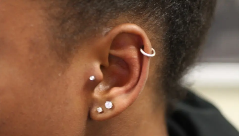 Orelha com brincos e piercing, em imagem ilustrativa sobre o caso envolvendo adolescente.