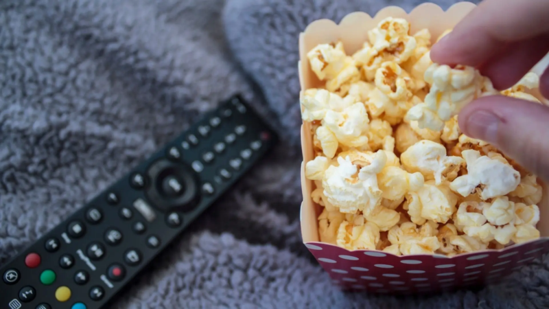 Pipoca e controle remoto representam momento de assistir a séries na televisão