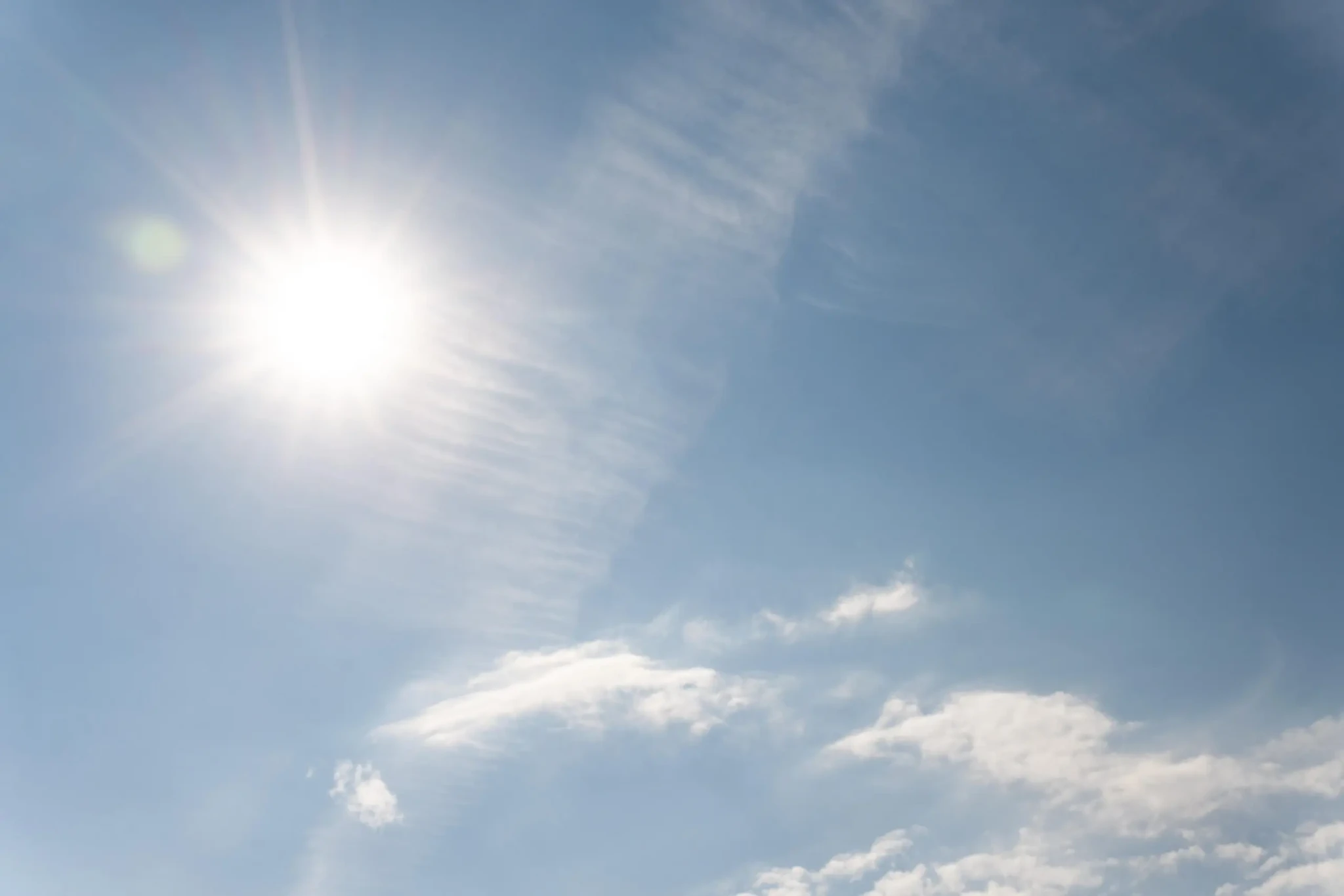 Sol forte em céu parcialmente nublado durante onda de calor em Goiás.