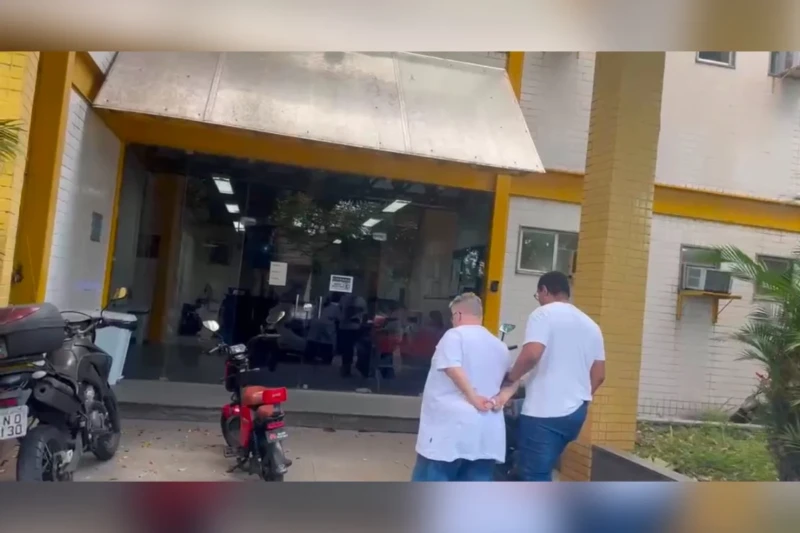 Policiais conduzem líder religioso preso durante operação da Polícia Civil no Rio de Janeiro.