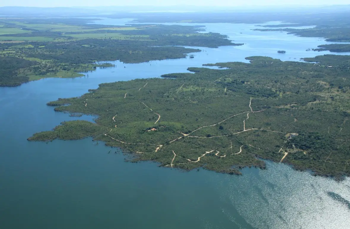 Vista aérea do Lago Serra da Mesa, em Goiás, cercado por áreas de vegetação.