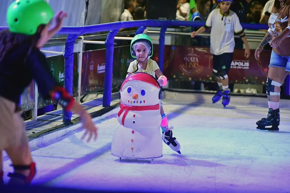 Criança patina em pista de gelo durante programação de Natal em Anápolis.