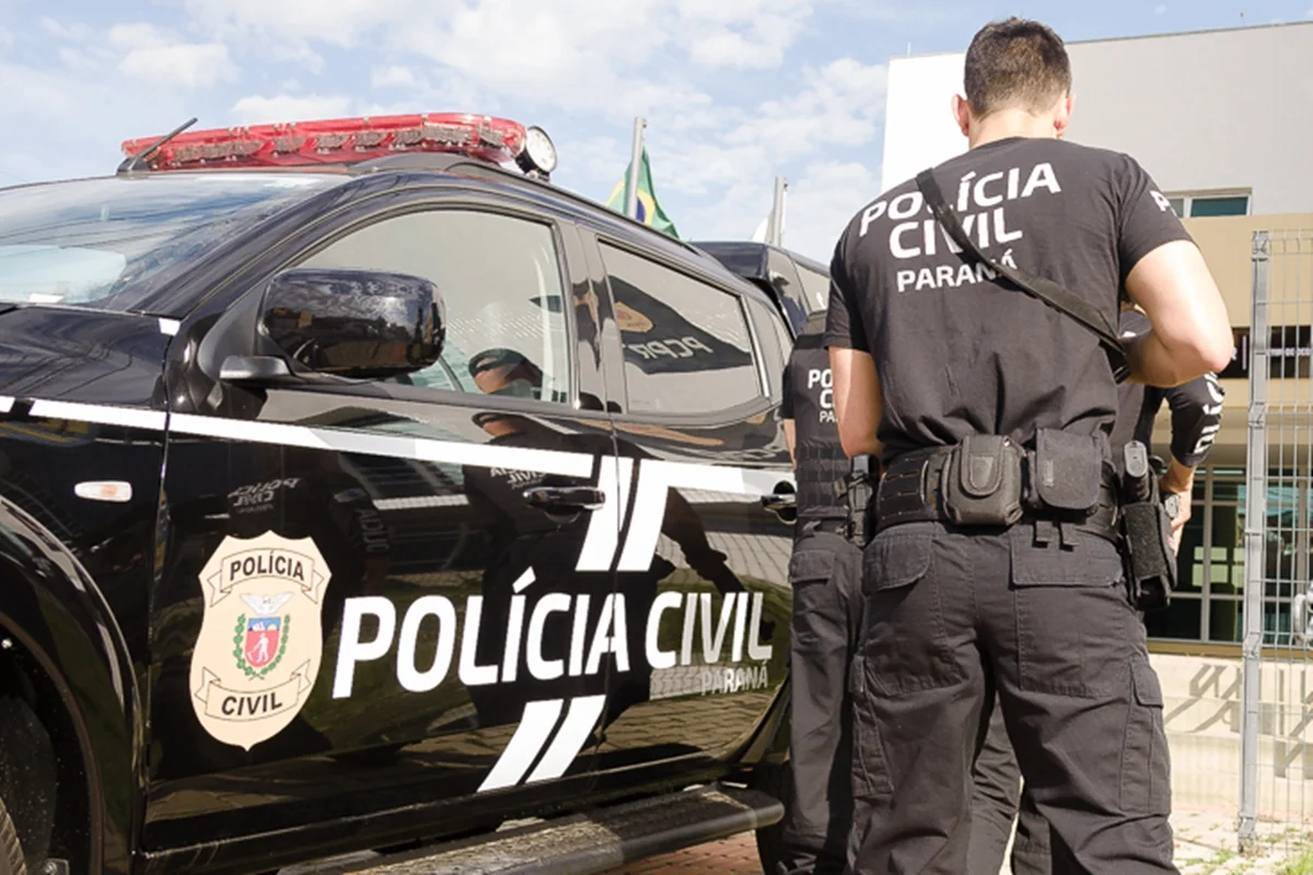Agentes da Polícia Civil do Paraná ao lado de uma viatura durante operação policial.