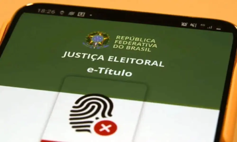 Celular exibe a tela do aplicativo e-Título, da Justiça Eleitoral, com símbolo de identificação biométrica.
