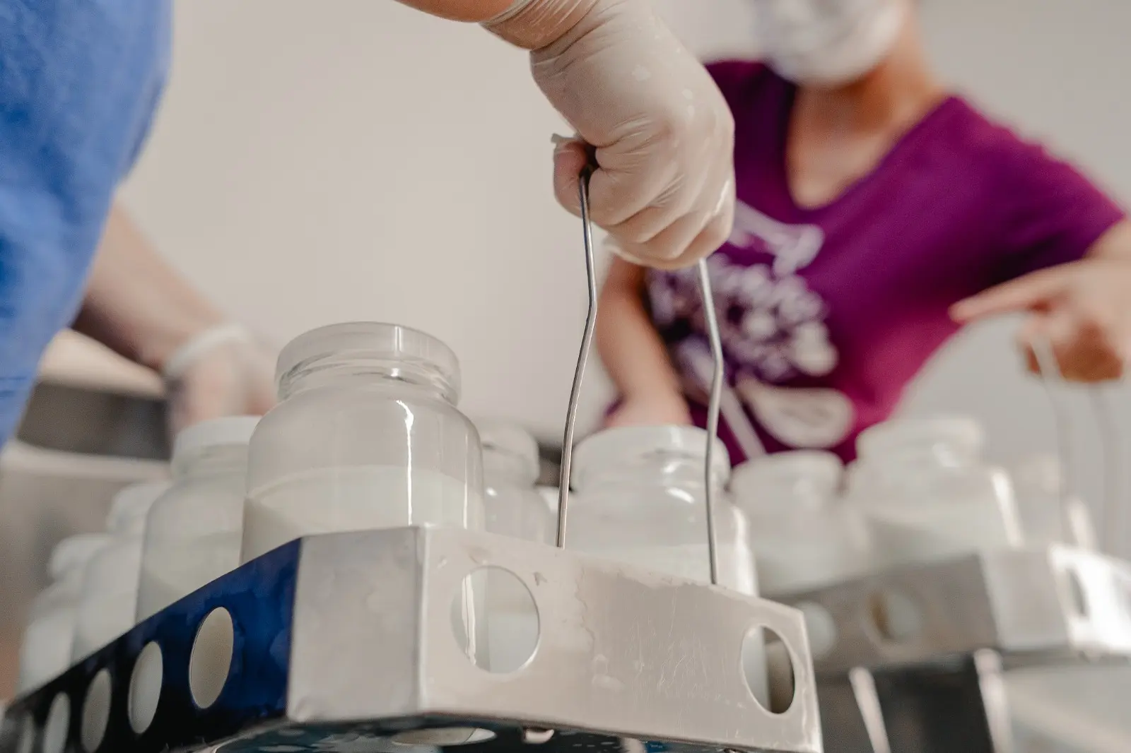 Profissional manuseia frascos com leite humano no Banco de Leite, durante processo de preparação das doações.