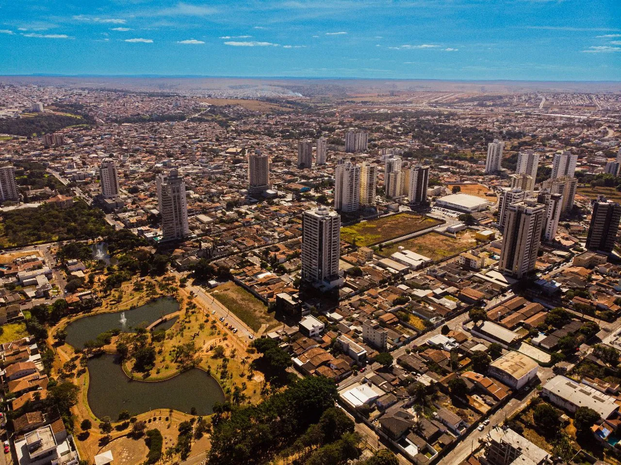 Vista aérea de Anápolis, com prédios, casas e um parque com lagos em primeiro plano