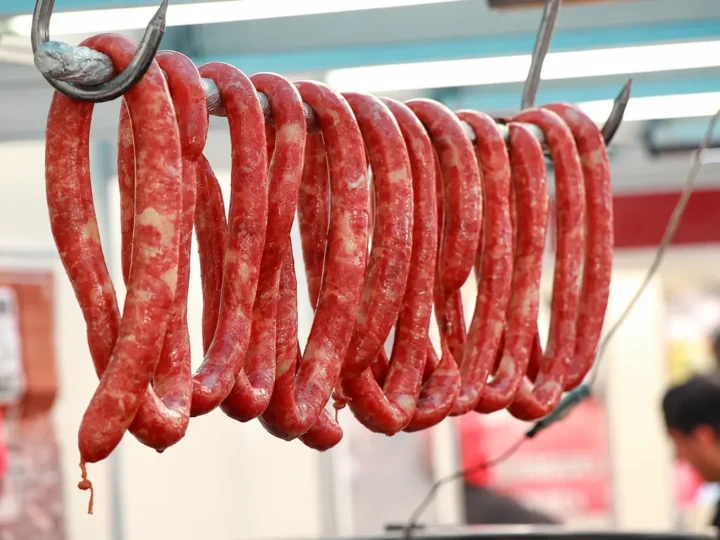 Linguiças penduradas em uma barra metálica em estabelecimento comercial. Imagem ilustrativa.