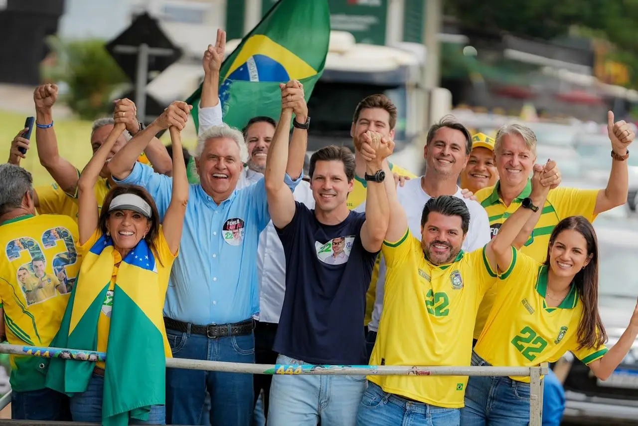 Grupo de pessoas com camisetas verdes e amarelas e bandeira do Brasil participa de uma mobilização política.