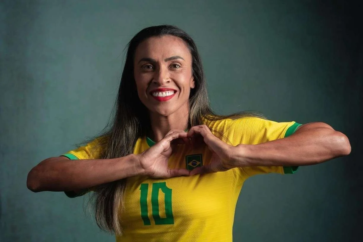 Marta sorri com a camisa número 10 da Seleção Brasileira e faz um coração com as mãos