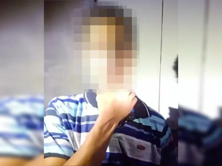 Adolescente com o rosto pixelado, usando camisa listrada e com uma das mãos próxima ao pescoço.